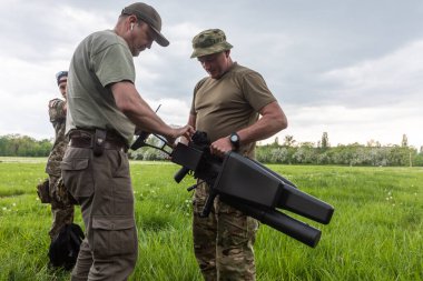 KYIV, UKRAINE - 14 Mayıs 2022: Bir asker, Ukrayna 'nın başkenti Kyiv' in sunumu kapsamında Toronto, Kanada 'daki bir yardım konseri sırasında toplanan bir insansız hava aracı tüfeği satın aldı.
