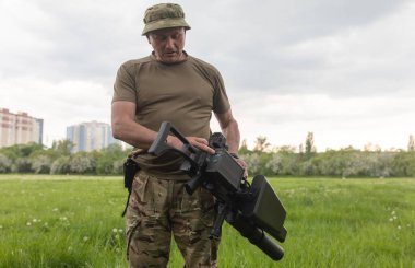 KYIV, UKRAINE - 14 Mayıs 2022: Bir asker, Ukrayna 'nın başkenti Kyiv' in sunumu kapsamında Toronto, Kanada 'daki bir yardım konseri sırasında toplanan bir insansız hava aracı tüfeği satın aldı.