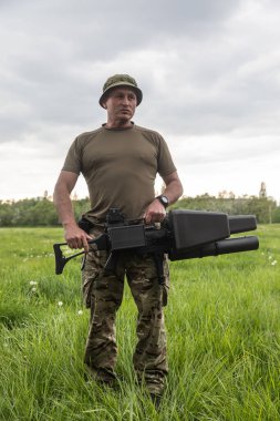 KYIV, UKRAINE - 14 Mayıs 2022: Bir asker, Ukrayna 'nın başkenti Kyiv' in sunumu kapsamında Toronto, Kanada 'daki bir yardım konseri sırasında toplanan bir insansız hava aracı tüfeği satın aldı.