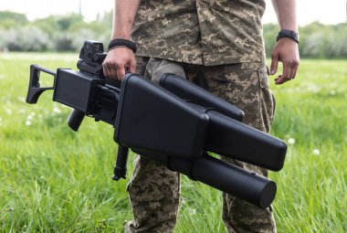 KYIV, UKRAINE - 14 Mayıs 2022: Bir asker, Ukrayna 'nın başkenti Kyiv' in sunumu kapsamında Toronto, Kanada 'daki bir yardım konseri sırasında toplanan bir insansız hava aracı tüfeği satın aldı.