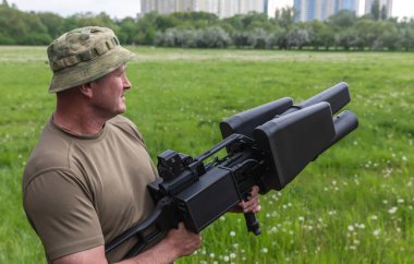 KYIV, UKRAINE - 14 Mayıs 2022: Bir asker, Ukrayna 'nın başkenti Kyiv' in sunumu kapsamında Toronto, Kanada 'daki bir yardım konseri sırasında toplanan bir insansız hava aracı tüfeği satın aldı.