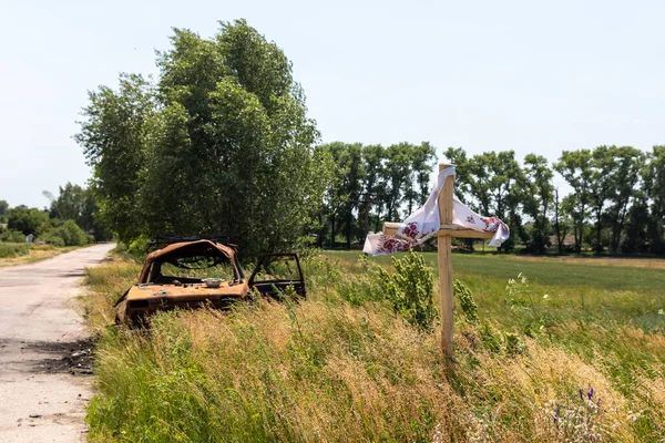 Chernihiv Reg Ukraine Jun 2022年9月19日 一辆烧毁的汽车停在路边 背景是一片麦田和一个坟墓十字架 俄罗斯法西斯入侵后的乌克兰景观 — 图库照片