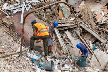 KHARKIV, UKRAINE - Aug. 01, 2022: Volunteers clearing the rubble of a destroyed house as a result of the Russian shelling of the city of Kharkiv