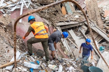 KHARKIV, UKRAINE - Aug. 01, 2022: Volunteers clearing the rubble of a destroyed house as a result of the Russian shelling of the city of Kharkiv