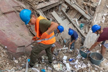 KHARKIV, UKRAINE - Aug. 01, 2022: Volunteers clearing the rubble of a destroyed house as a result of the Russian shelling of the city of Kharkiv