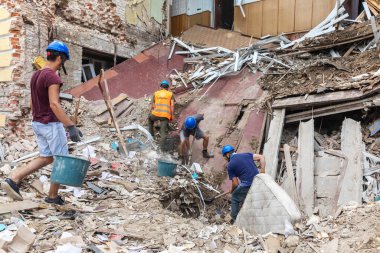 KHARKIV, UKRAINE - Aug. 01, 2022: Volunteers clearing the rubble of a destroyed house as a result of the Russian shelling of the city of Kharkiv