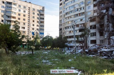 KHARKIV, UKRAINE - Jul. 29, 2022: Destroyed residential building as a consequences of Russian missile shelling in the North Saltivka, Kharkiv, Ukraine. The inscription - Russia is a terrorist country