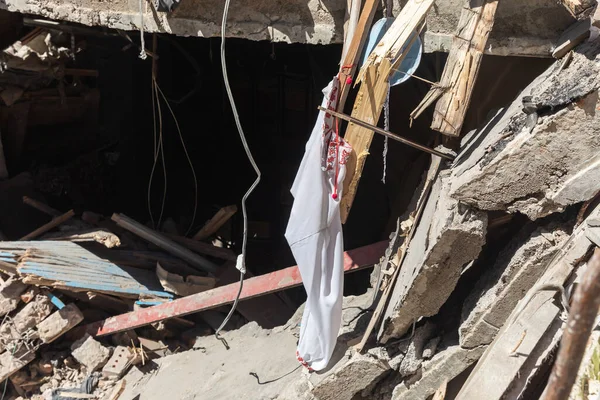 CHUHUIV, UKRAINE - Jul. 29, 2022: Traditional Ukrainian shirt is seen in the middle of destroyed by rocket the cultural center in Chuhuiv, Kharkiv region, Ukraine