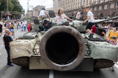 KYIV, UKRAINE - Aug. 20, 2022: Children on tanks. An exhibition of destroyed Russian equipment is being organized on Khreshchatyk in Kyiv