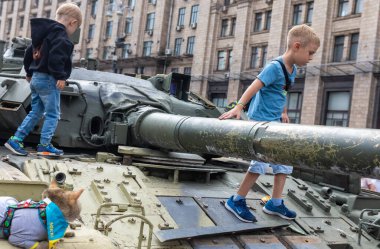 KYIV, UKRAINE - Aug. 20, 2022: Children on tanks. An exhibition of destroyed Russian equipment is being organized on Khreshchatyk in Kyiv