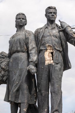 KHARKIV, UKRAINE - Jul. 30, 2022: Sculpture Miner and Collective Farm Woman in Kharkiv damaged by fragments of exploding shells during shelling. The streets of Kharkiv during the war with the Russian Federation.