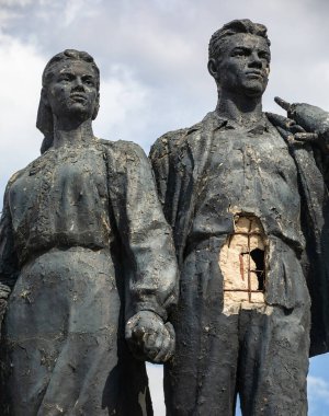 KHARKIV, UKRAINE - Jul. 30, 2022: Sculpture Miner and Collective Farm Woman in Kharkiv damaged by fragments of exploding shells during shelling. The streets of Kharkiv during the war with the Russian Federation.