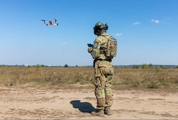 KYIV REG., UKRAINE - Sep. 08, 2022: A drone operator from field medicine division Hospitallers launch a quadrocopter to search for the wounded on the battlefield. Field tests of THeMIS crawler drone