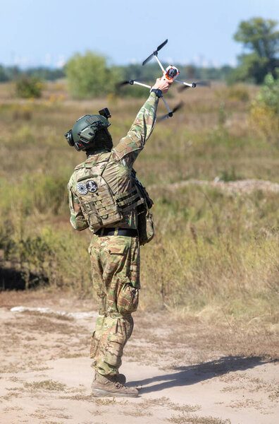 KYIV REG., UKRAINE - Sep. 08, 2022: A drone operator from field medicine division Hospitallers launch a quadrocopter to search for the wounded on the battlefield. Field tests of THeMIS crawler drone