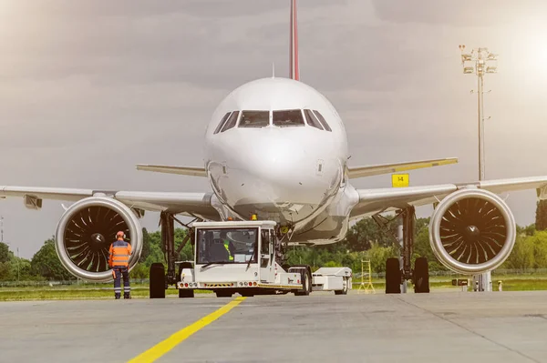 Opérations terrestres à l'aire de trafic de l'aéroport. Opérations sur piste sur fond de ciel bleu. Vue d'ensemble des opérations de l'aéroport avec tracteur remorqueur. Image En Vente