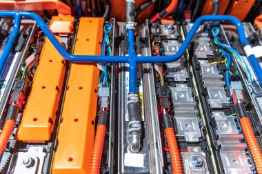 Electric car battery with power connections closeup. Blue toned. EV car battery at maintenance