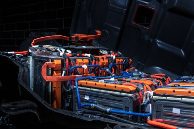 Electric car battery with power connections closeup. Blue toned. EV car battery at maintenance