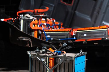 Electric car lithium power cell with power connections in front of maintained car battery. EV car battery at maintenance