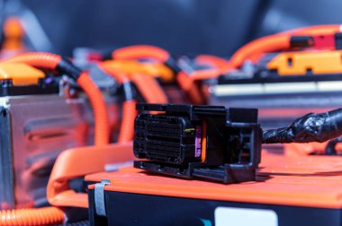 Electric car battery with power connections closeup. Blue toned. EV car battery at maintenance. High voltage power connector closeup
