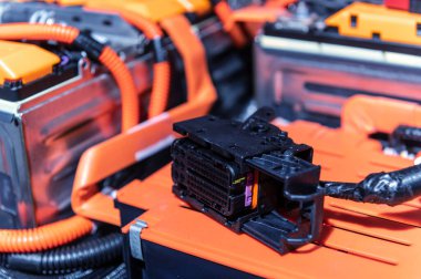Electric car battery with power connections closeup. Blue toned. EV car battery at maintenance. High voltage power connector closeup