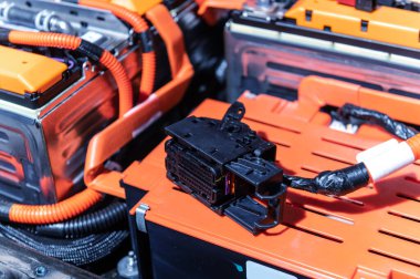 Electric car battery with power connections closeup. Blue toned. EV car battery at maintenance. High voltage power connector closeup