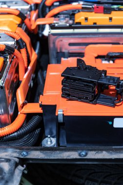 Electric car battery with power connections closeup. Blue toned. EV car battery at maintenance. High voltage power connector closeup