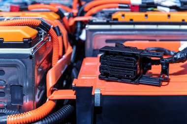Electric car battery with power connections closeup. Blue toned. EV car battery at maintenance. High voltage power connector closeup