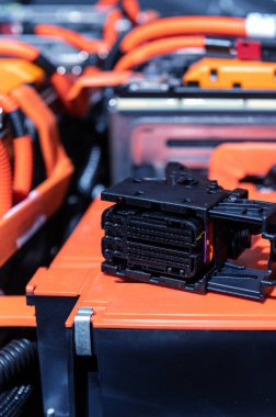 Electric car battery with power connections closeup. Blue toned. EV car battery at maintenance. High voltage power connector closeup