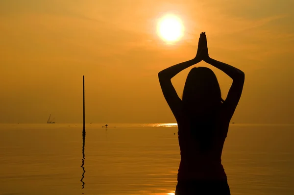 Ragazza asiatica che esegue yoga su una spiaggia — Foto Stock