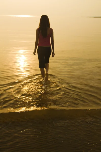 Silhouette asiatisk tjej går på en strand — Stockfoto