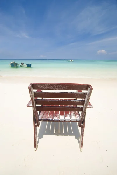 Пляж с одиноким стулом — стоковое фото