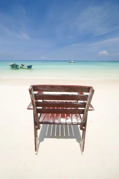 Una playa con una silla solitaria — Foto de Stock