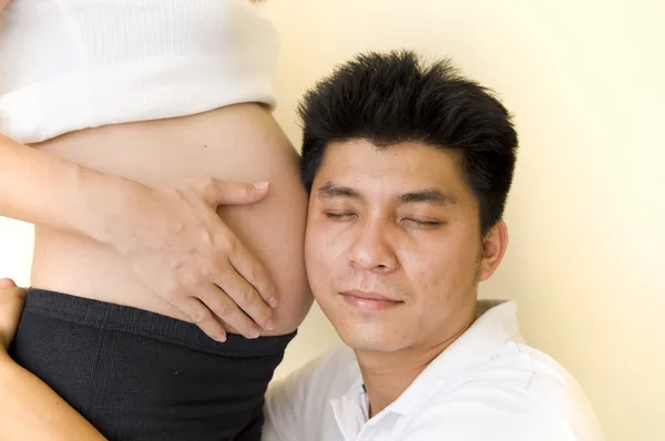 Un padre asiatico che ascolta il grembo di una madre asiatica — Foto Stock