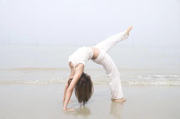 在海滩上表演瑜伽的亚洲女孩 — 图库照片