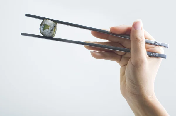 Mão com pauzinho segurando sushi — Fotografia de Stock