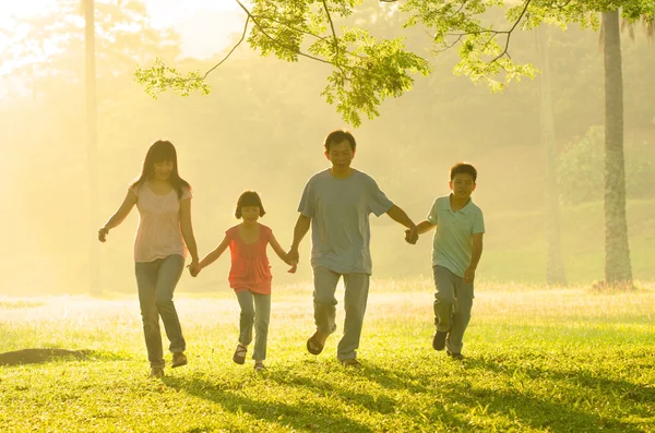 Une famille asiatique marche dans le parc pendant un beau lever de soleil , — Photo