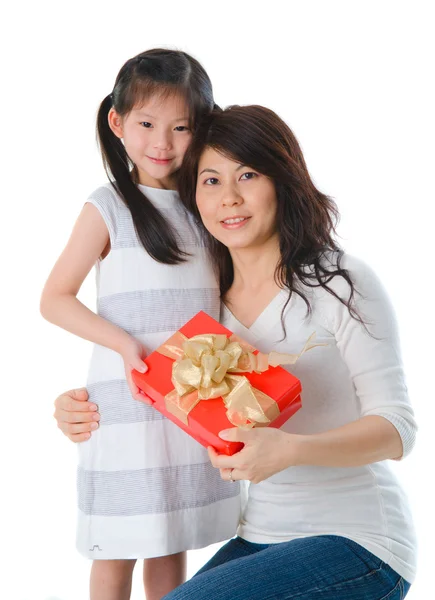 Kleines asiatisches Mädchen hält ein schön verpacktes Geschenk in den Armen. — Stockfoto