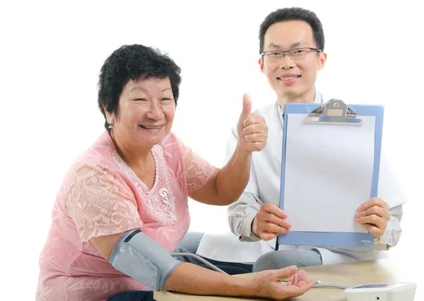 Aziatische senior vrouwelijke duimschroef opwaarts tijdens medische checkup met arts — Stockfoto