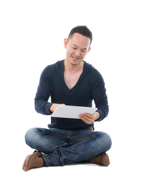 South east asian man med en tablett i casual — Stockfoto