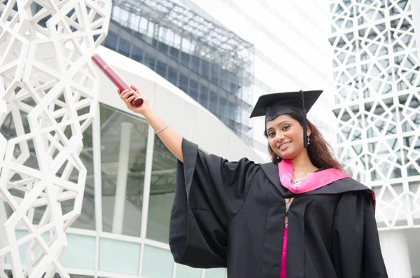 Молода індійська жінка випускниця з кампусом фону — стокове фото