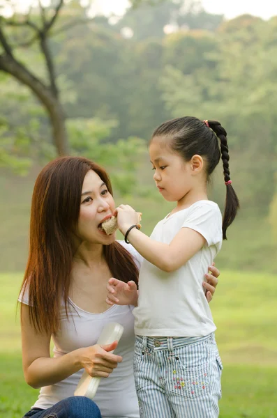 Aziatische Chinees meisje voederen van haar moeder in buiten groen park — Stockfoto