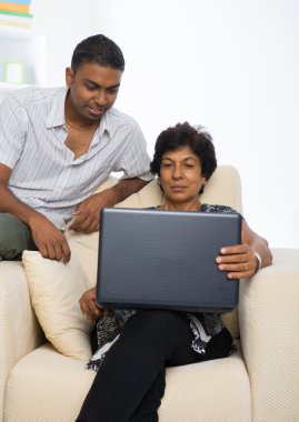 Hint aile, anne ve oğul dizüstü kullanarak internette sörf