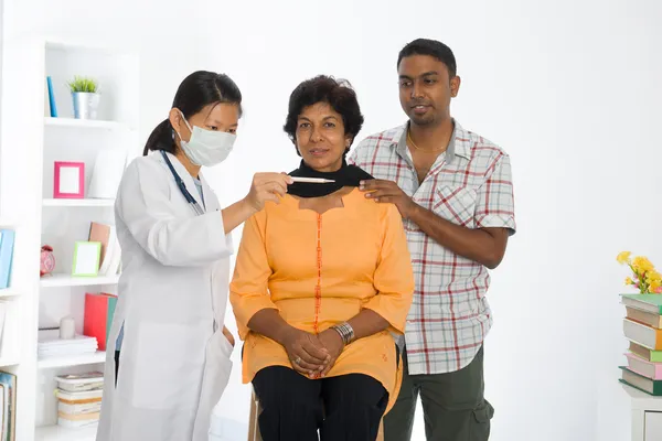 Indian senior citizen health check with a chinese female doctor — Stock Photo, Image