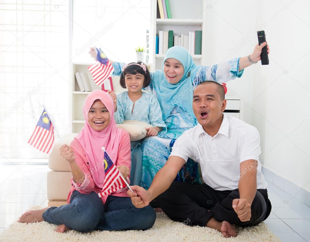 malaysian family celebrating while watching television over a to