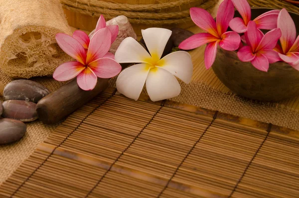 Tropical spa setup with frangipani flower hot rocks and massage — Stock Photo, Image
