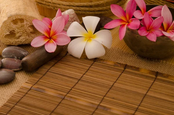 Configurazione spa tropicale con frangipani fiore rocce calde e massaggio — Foto Stock