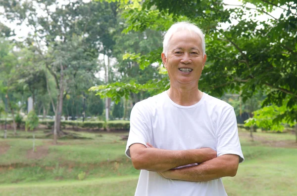 Chinese Aziatische senior man buiten met groene achtergrond — Stockfoto