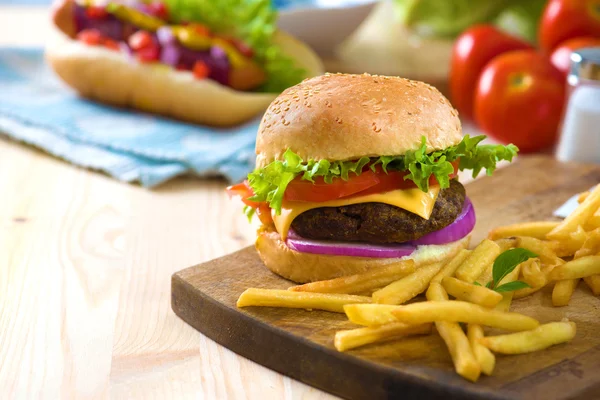 Hambúrguer fast food com abundância de matérias-primas no backgrou — Fotografia de Stock