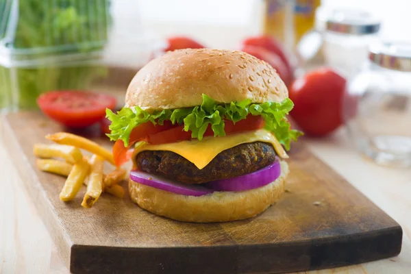 Hamburger a hranolky s fast food přísad na pozadí, vyřešit hádank — Stock fotografie