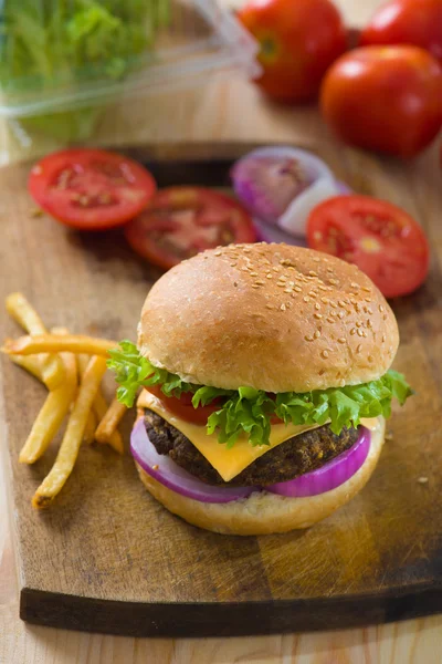 Burger with fast food items and materials on the background — Stock Photo, Image